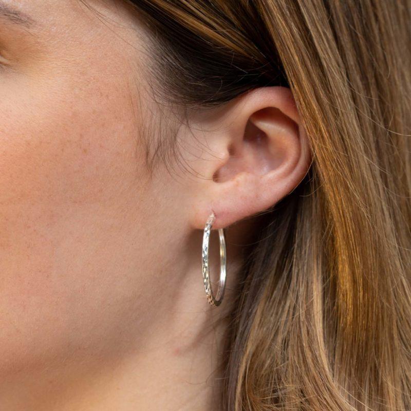 silver diamond cut hoop earrings on model