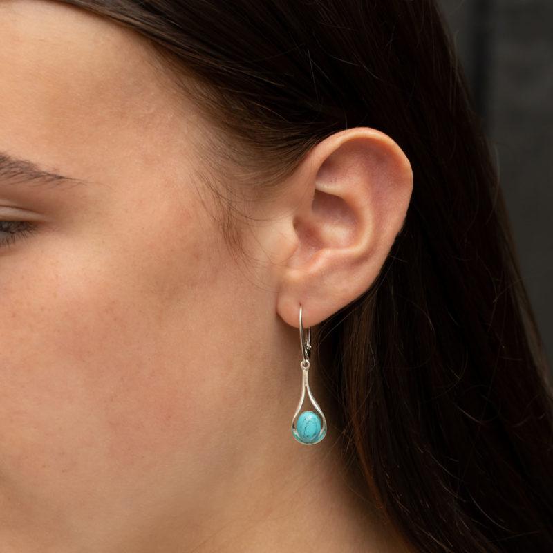 Silver turquoise drop earrings on model